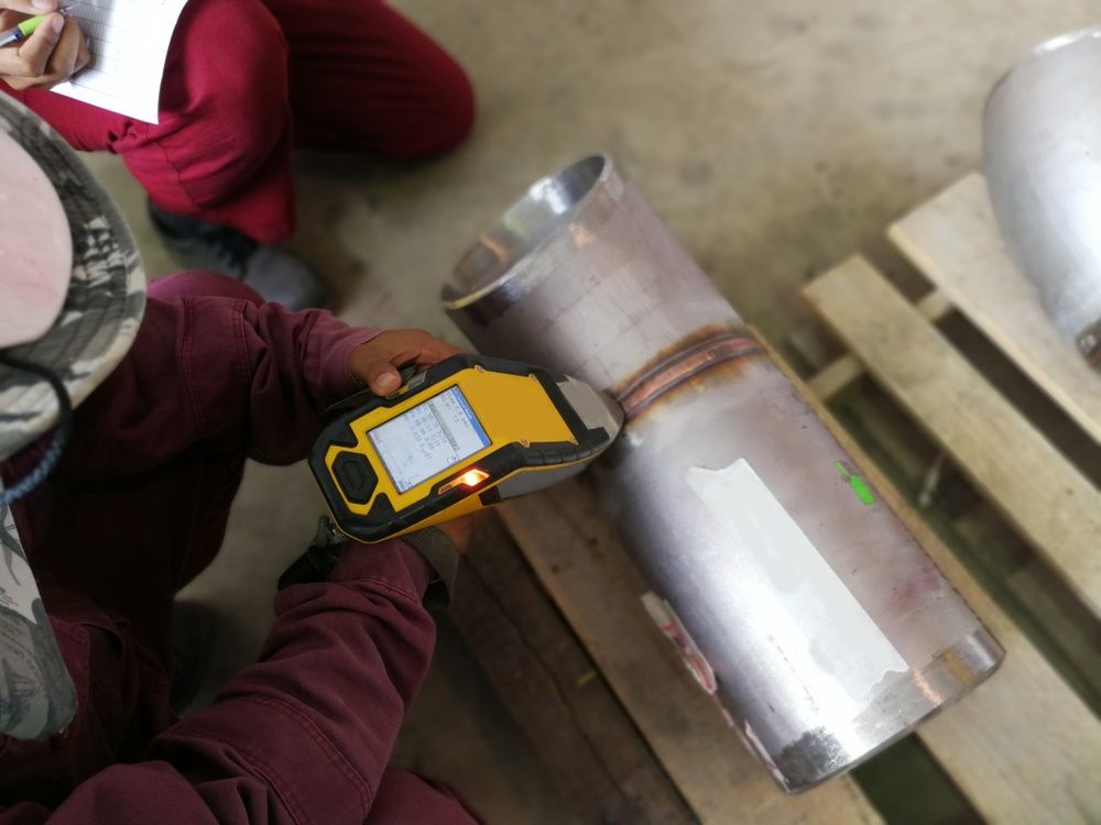 A Man Is Drawing A Blueprint With A Compass And A Hard Hat — Kaplan Engineering Pty Ltd In Bowen, QLD