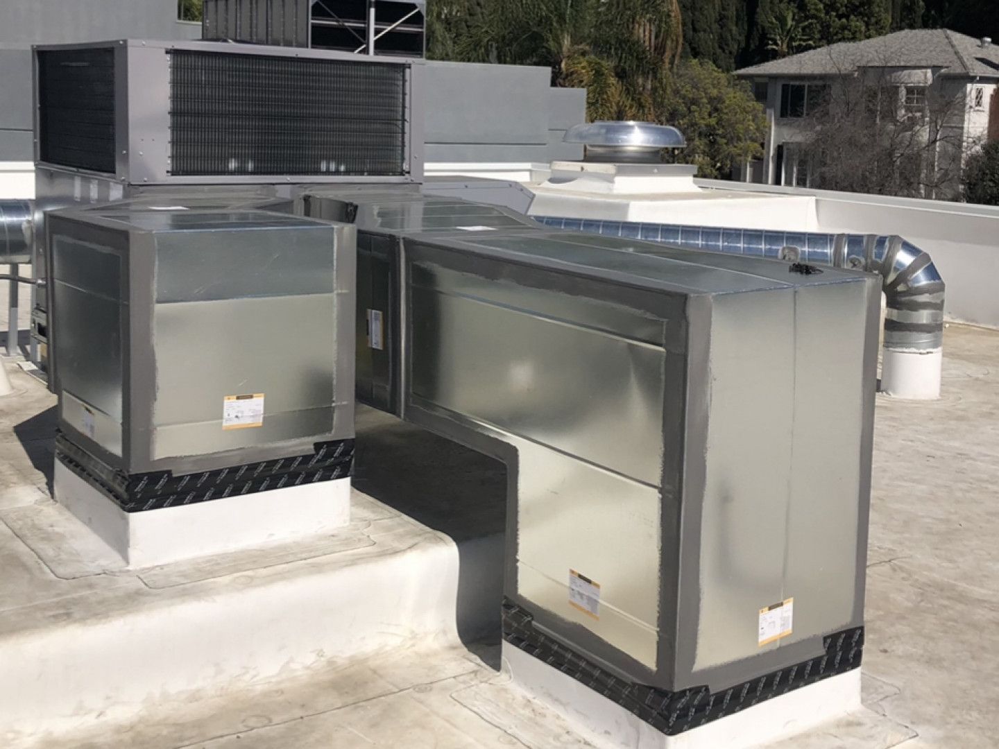 A couple of metal boxes sitting on top of a roof.