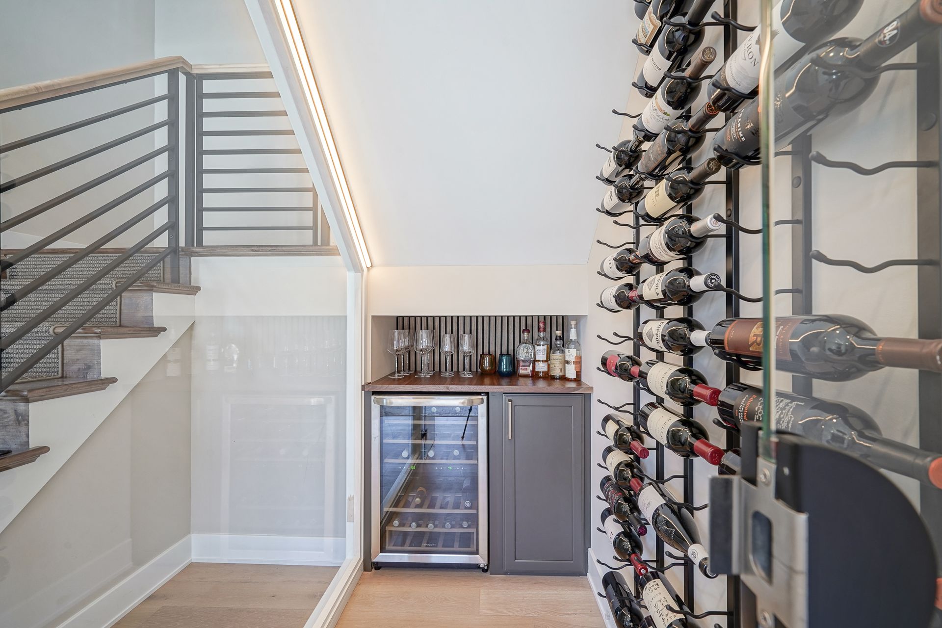 A wine cellar with lots of wine bottles and a refrigerator.