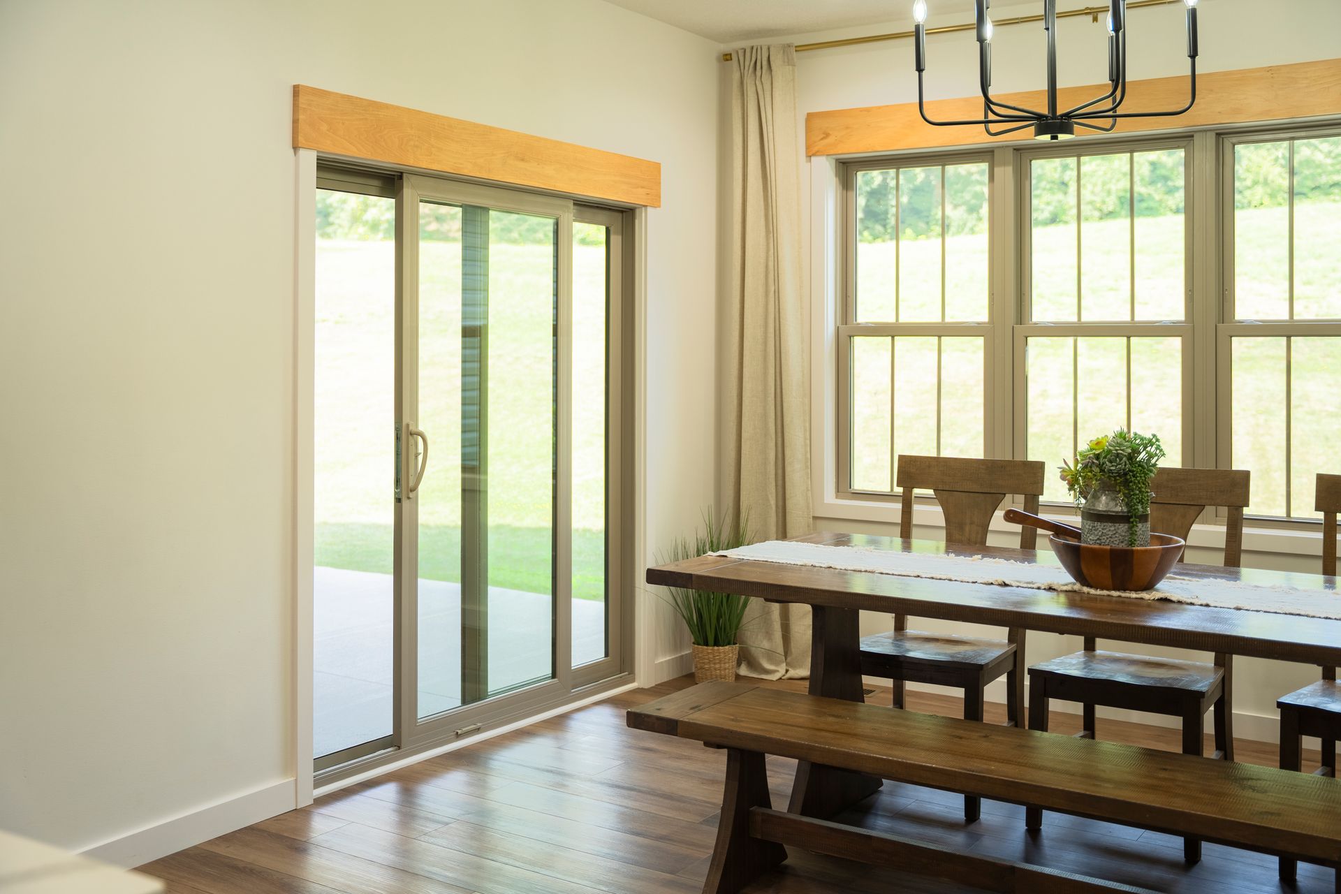 A dining room with a table and chairs and sliding glass doors.