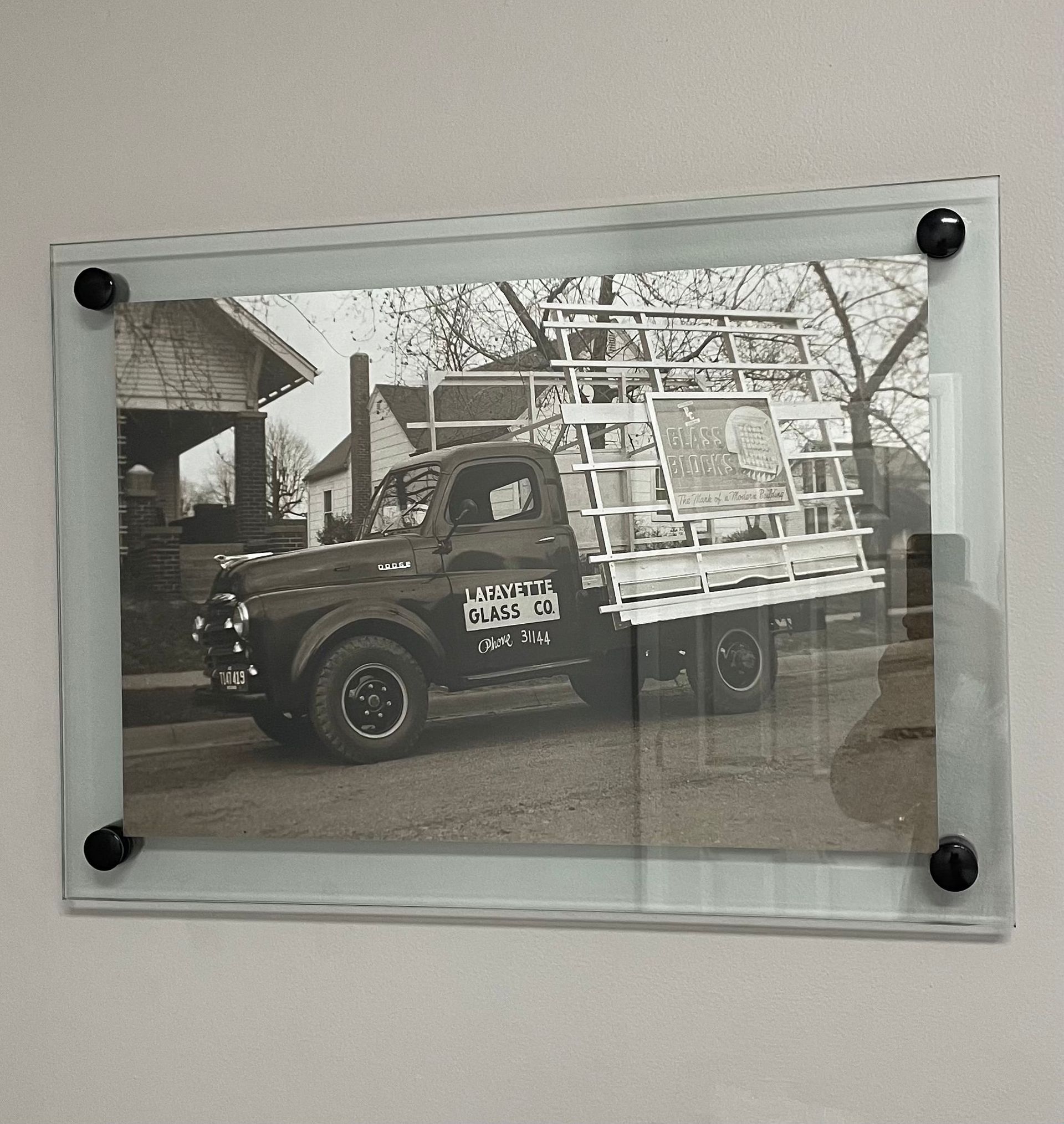 A black and white photo of a truck that says woodgate glass co.