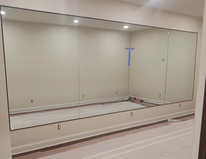 A large mirror is hanging on a wall in a room.