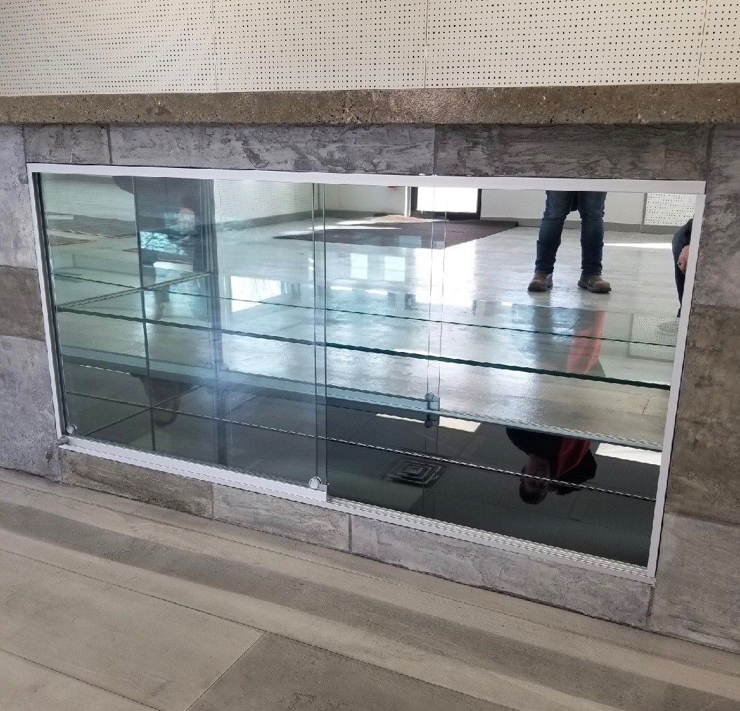 A person is standing in front of a large mirror.