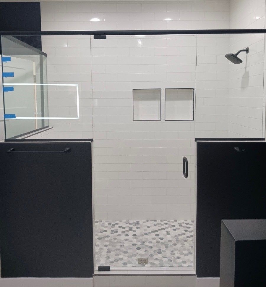 A bathroom with a sliding glass shower door and a shower head.