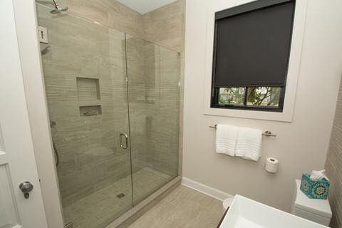 A bathroom with a walk in shower and a sink.