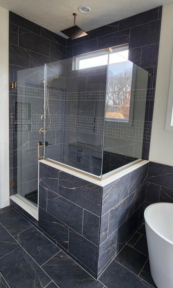 A bathroom with a walk in shower and a tub.