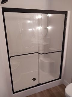 A bathroom with a sliding glass shower door and a toilet.