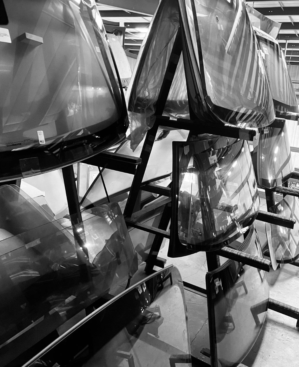A black and white photo of a stack of windshields