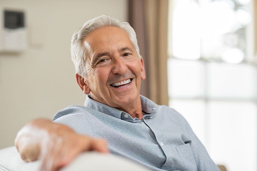mature man relaxing at home on the couch while smiling