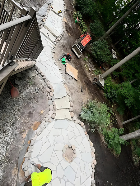 A group of people are working on a stone patio.
