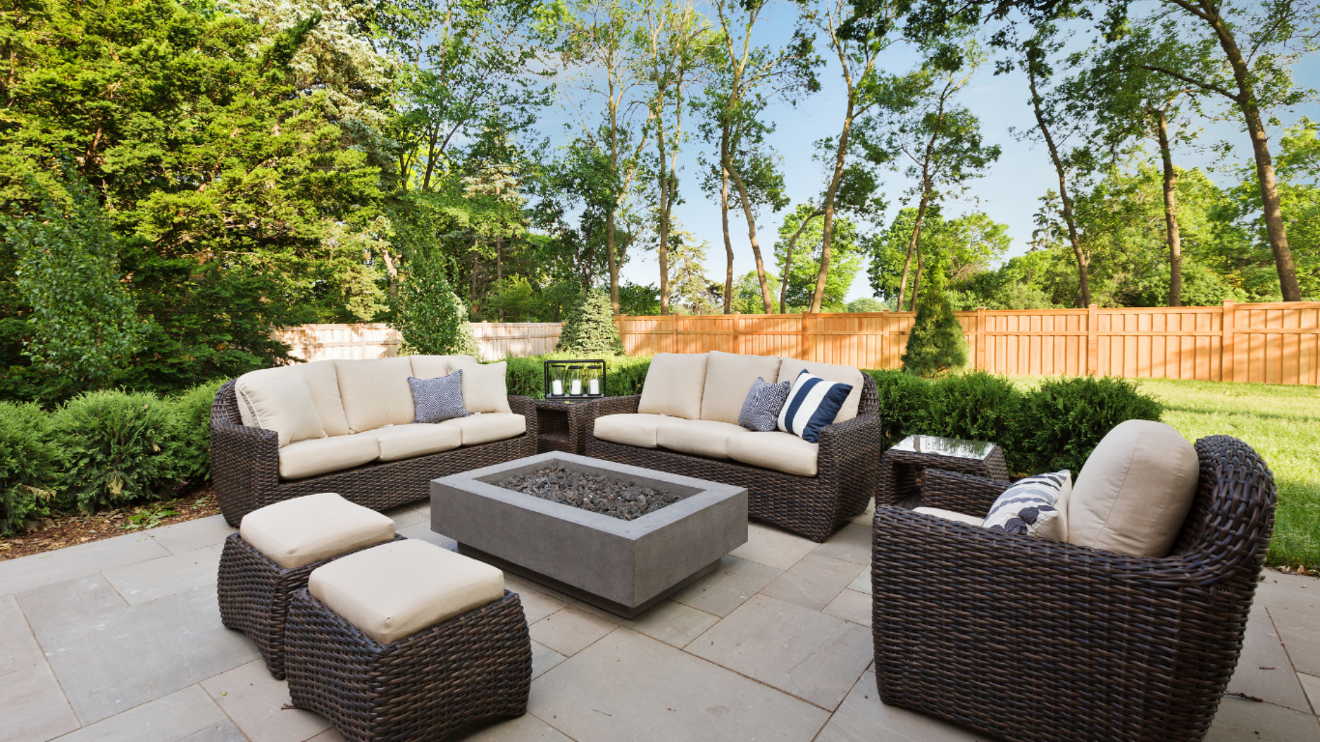 A patio with wicker furniture and a fire pit.
