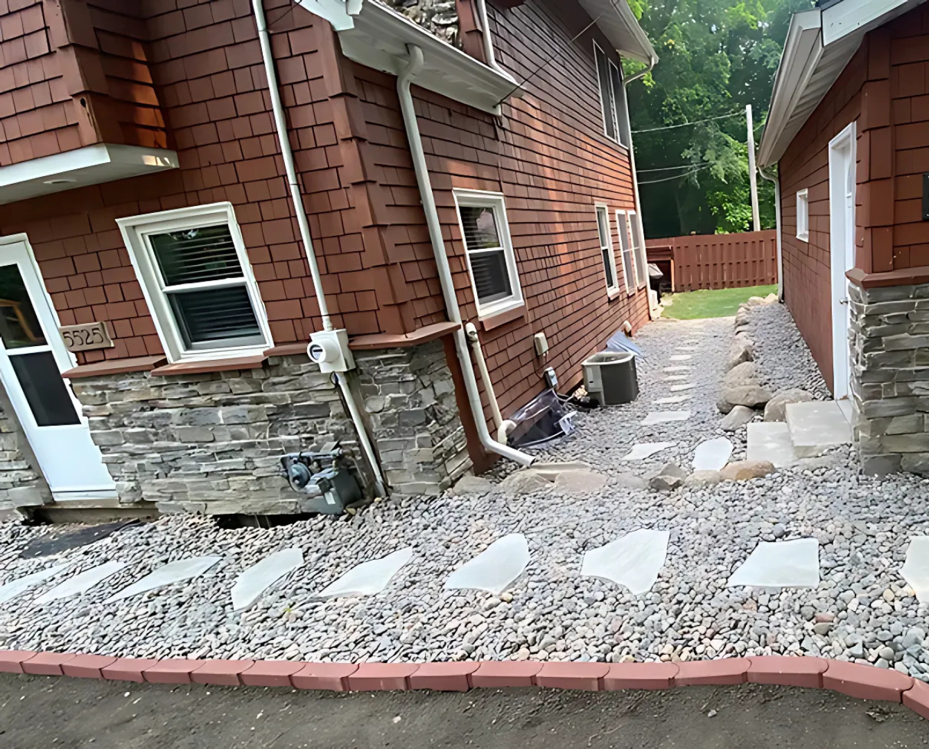 A brick house with a stone walkway leading to a garage.