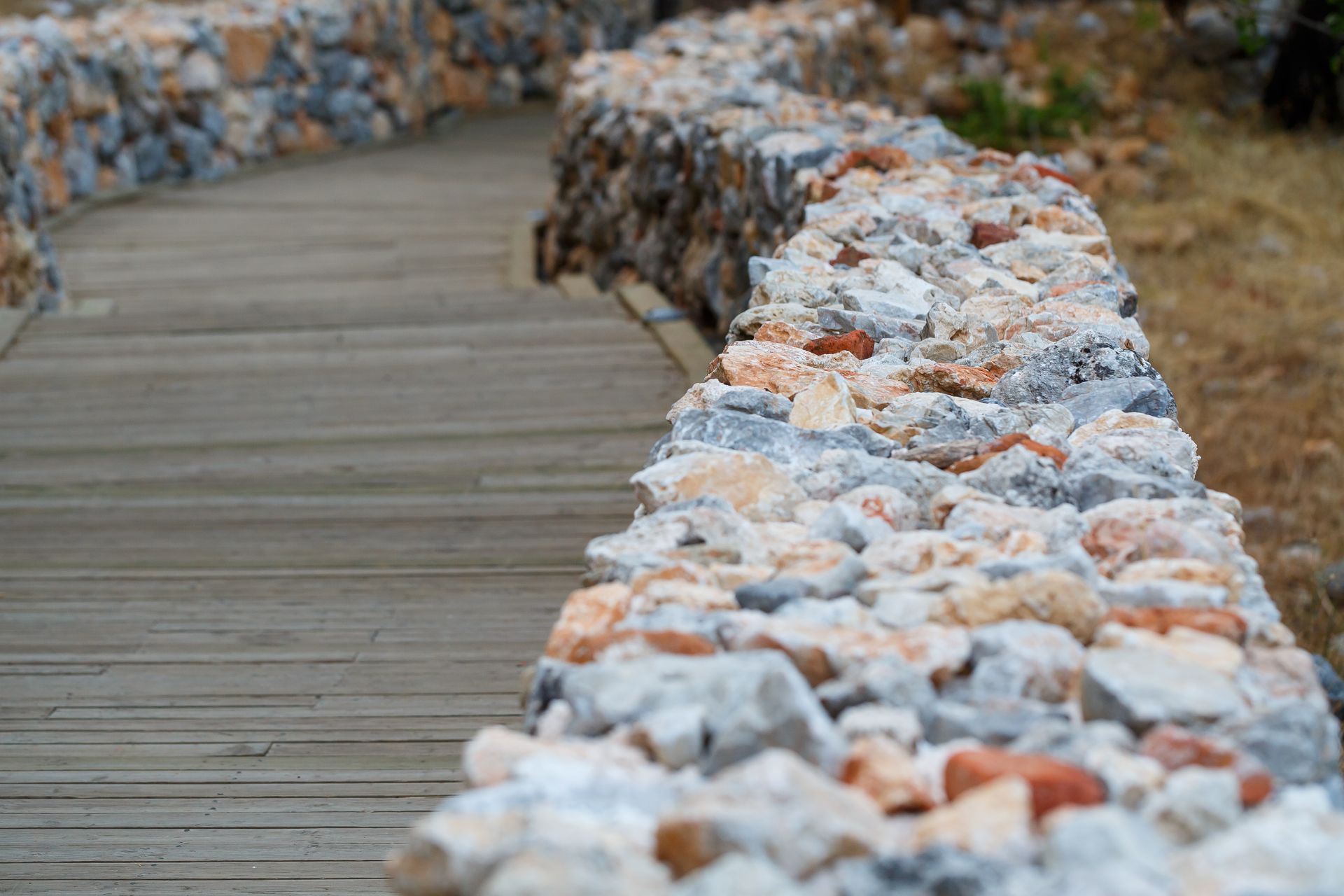 A wooden walkway going through a stone wall.