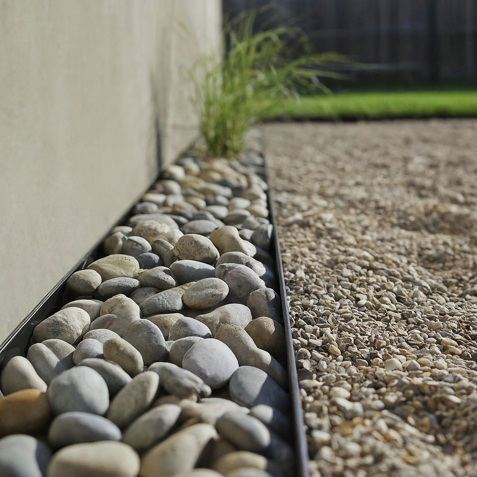 A pile of rocks and gravel next to a steel edging