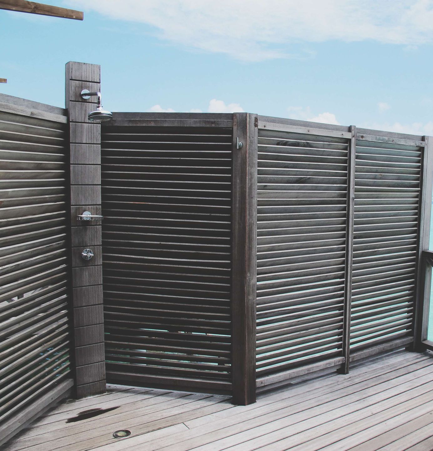 A wooden deck with a privacy screen.
