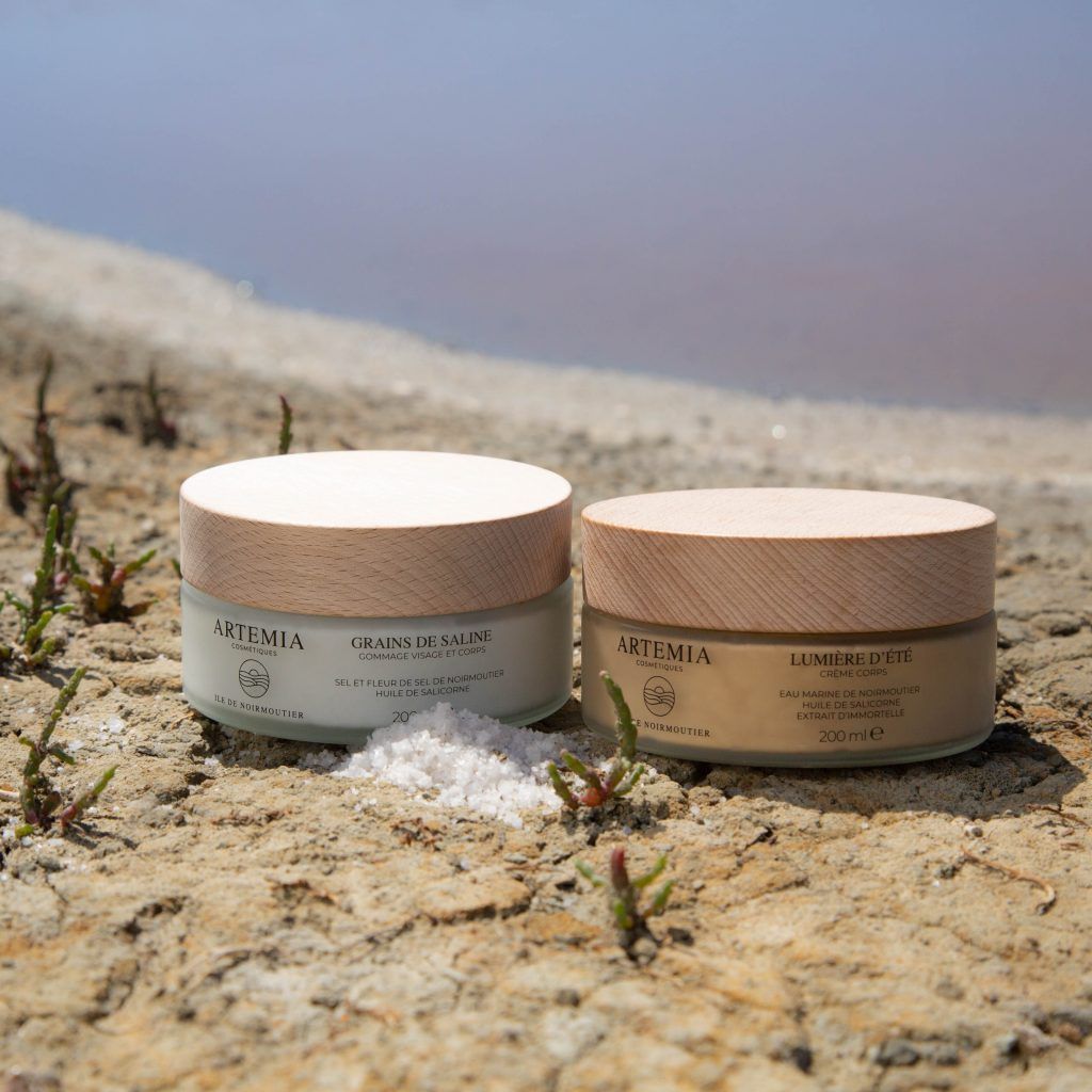 Deux pots de cosmétiques sont posés sur le sol l'un à côté de l'autre.