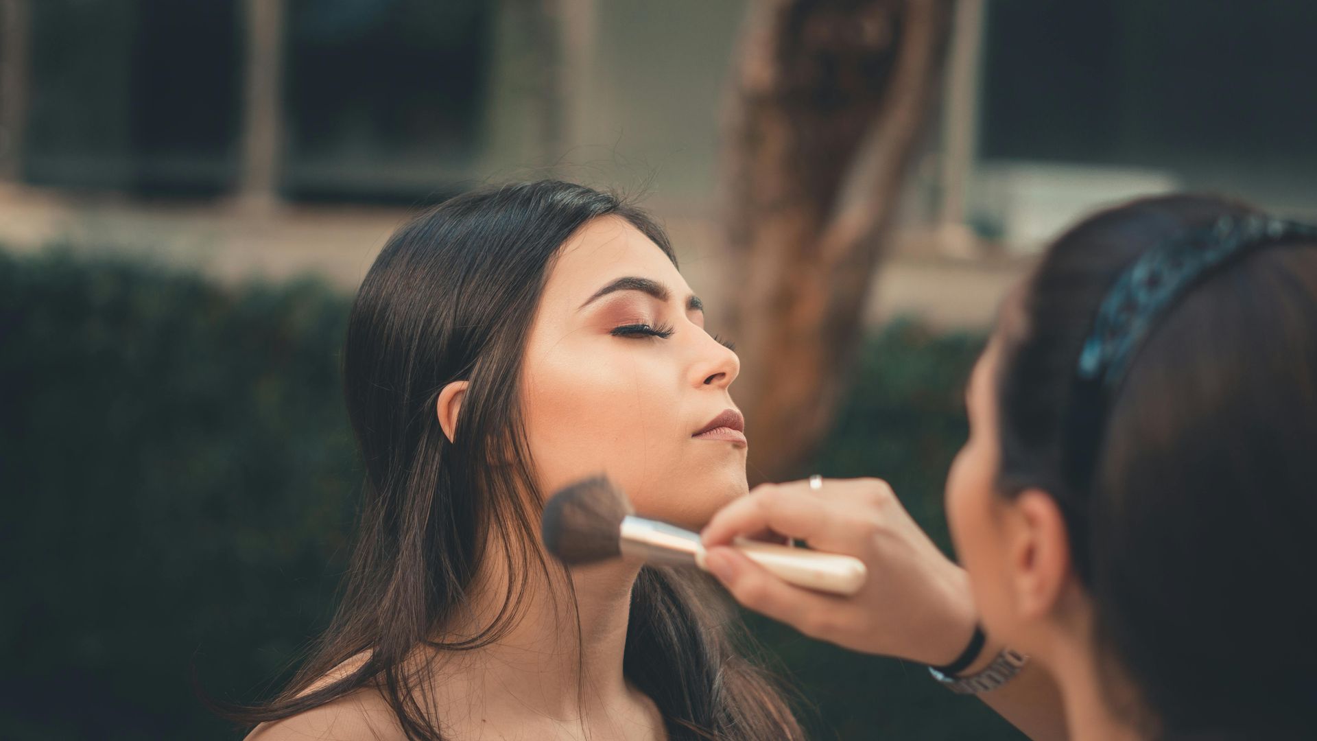 Une femme applique du maquillage sur le visage d'une autre femme.