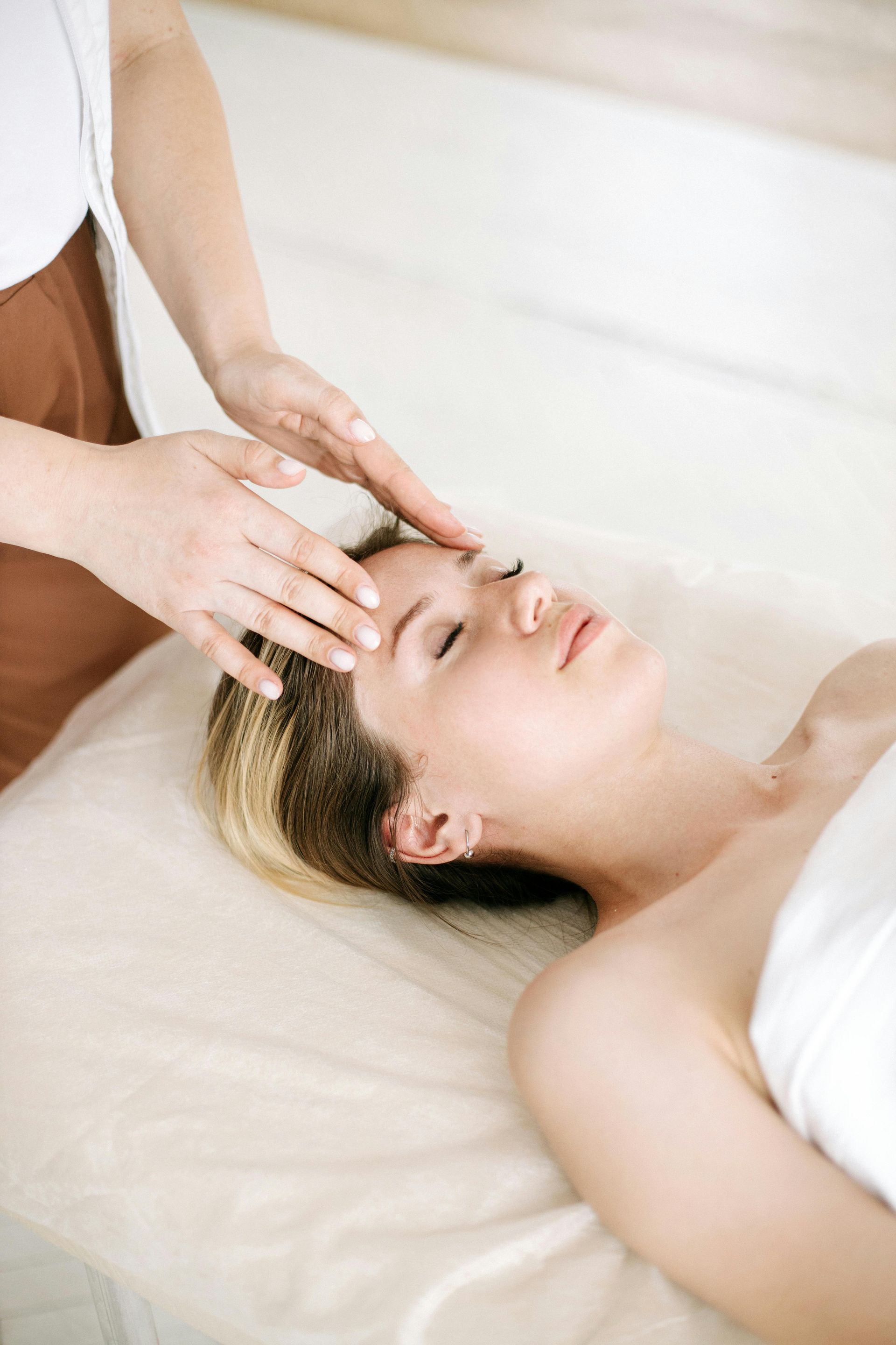Une femme reçoit un massage de la tête dans un spa.