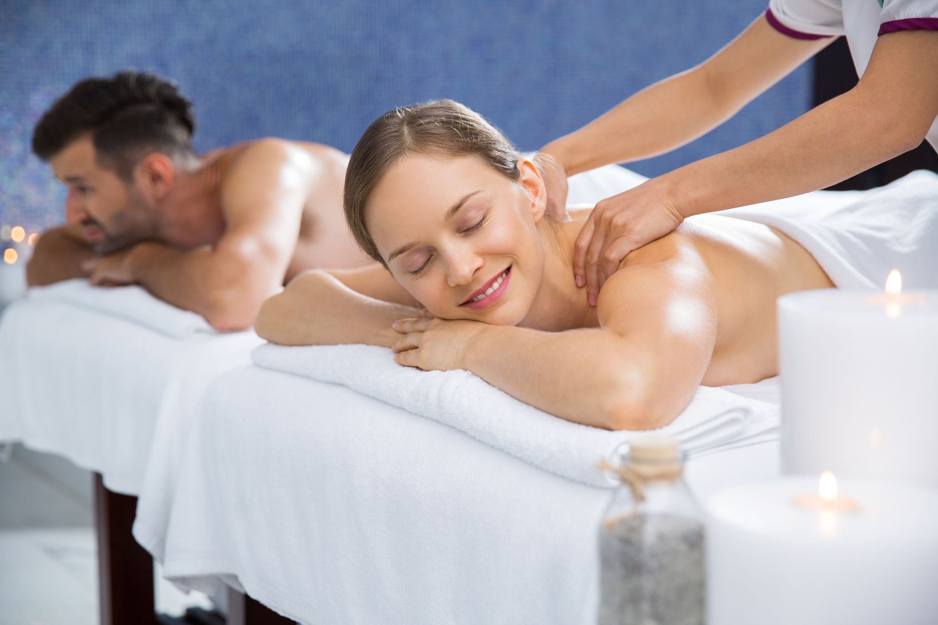 Un homme et une femme se font masser dans un spa.