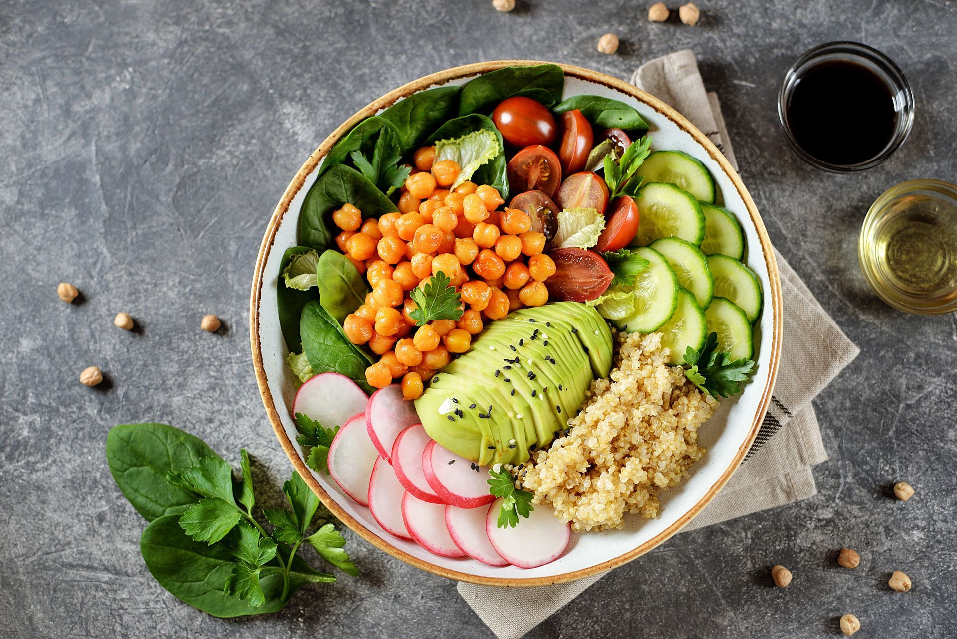 Healthy bowl with chickpeas, avocado, vegetables, and quinoa.