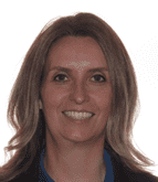 Woman with long light brown hair smiles, wearing a dark blazer and blue top.