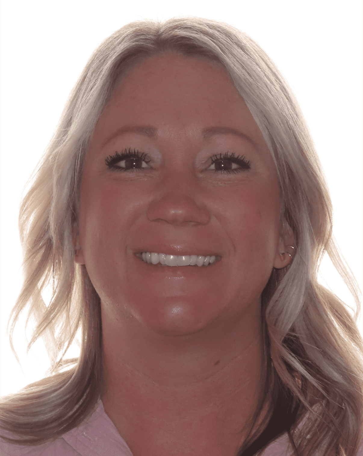 Woman with blonde hair smiling at the camera, wearing a pink top.