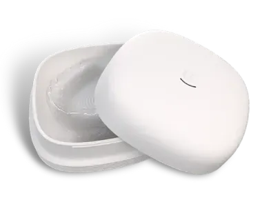 White retainer case, opened to reveal a clear dental appliance inside.