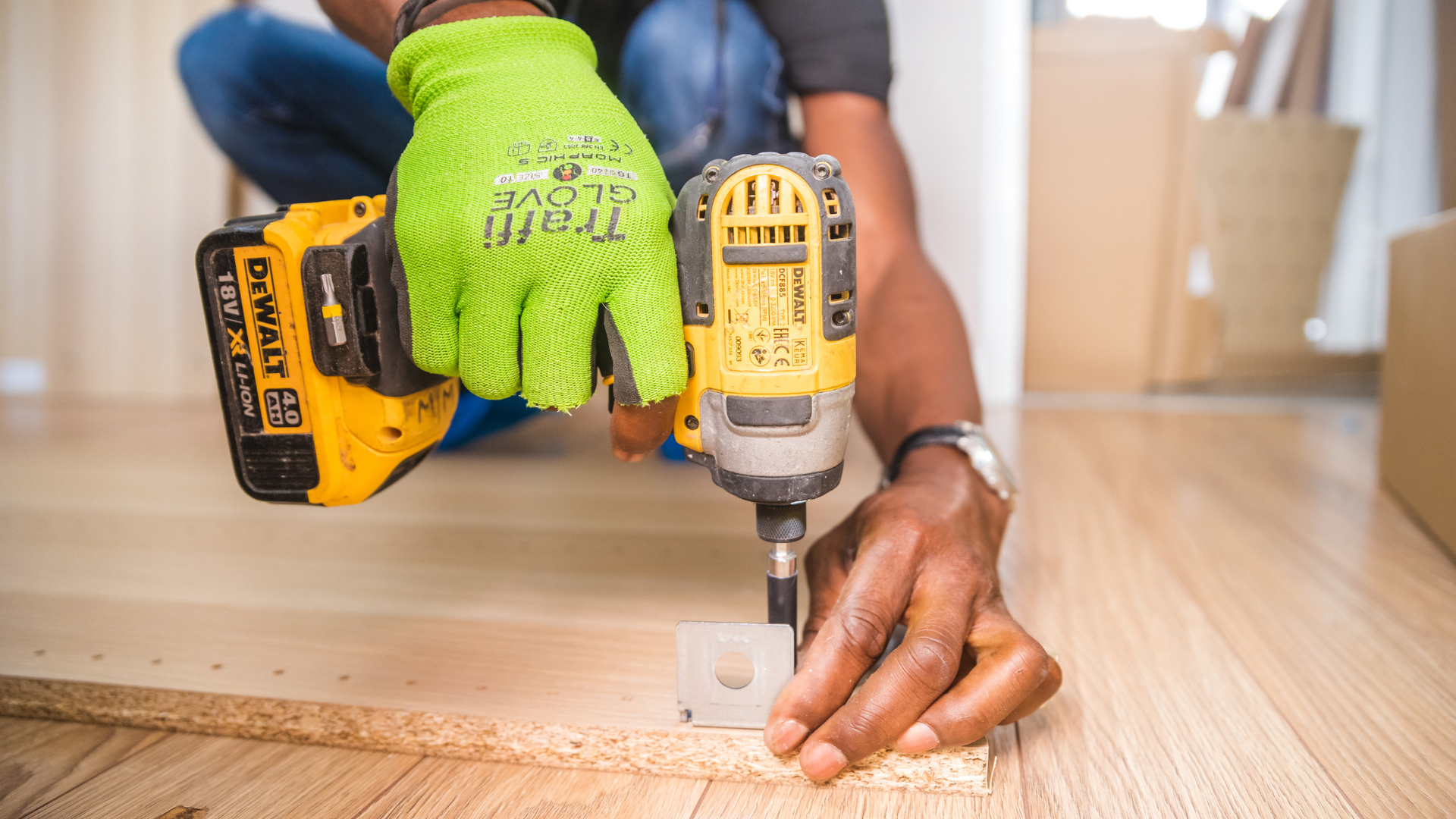 A man is using a drill to drill a hole in a piece of wood.