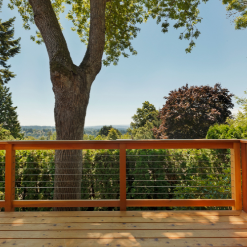 A wooden deck with a tree in the background