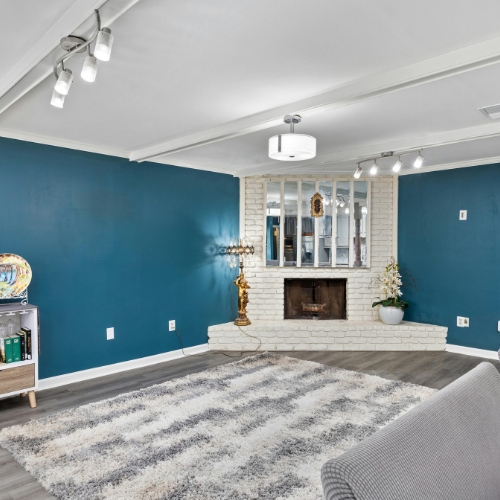 A living room with blue walls and a fireplace