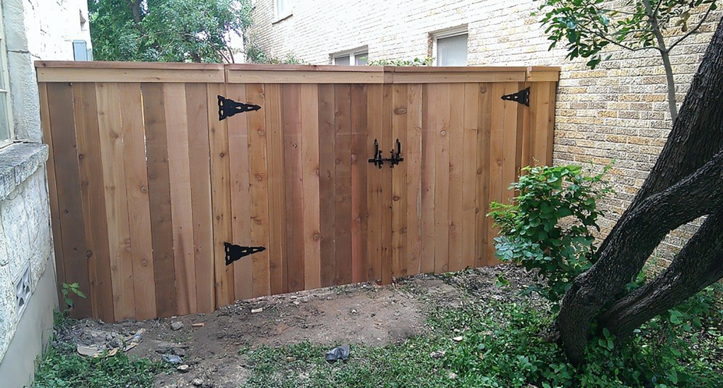 A wooden fence with a tree in the background