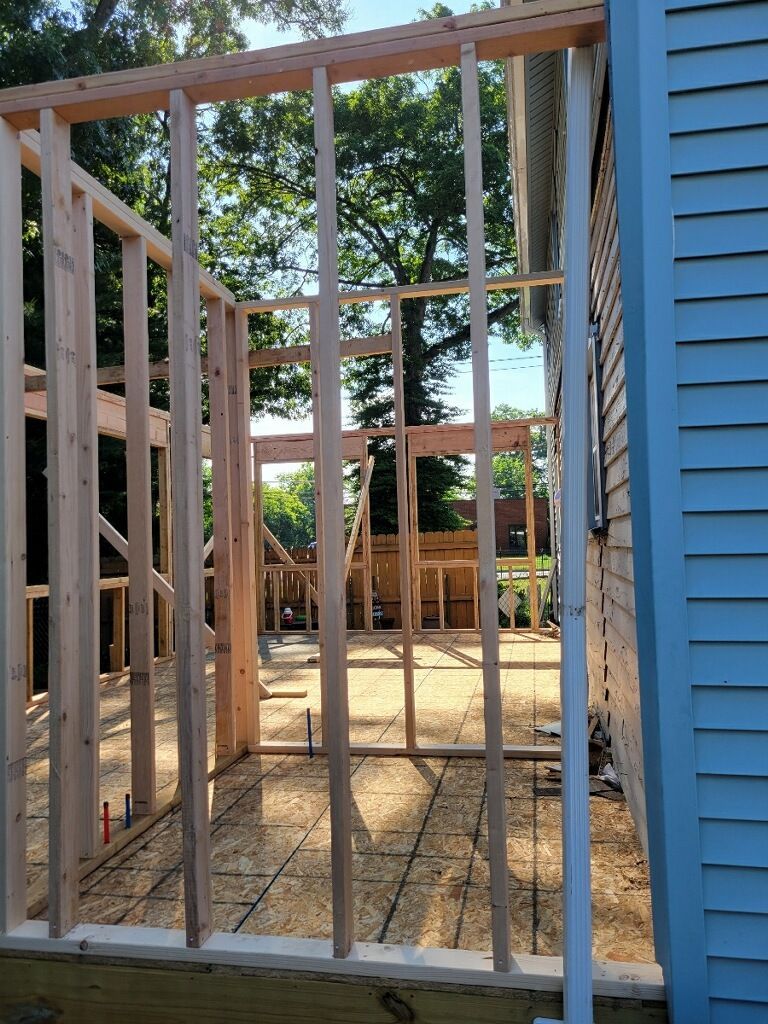 A house is being built with wooden beams and a blue siding.