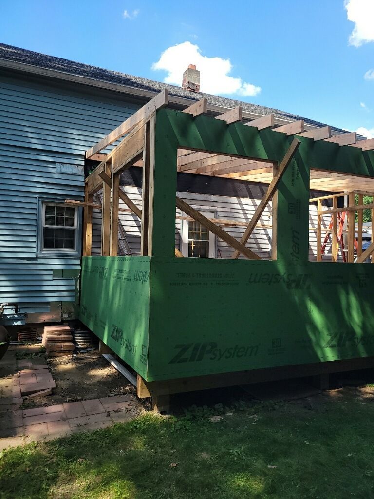 A house is being remodeled with a porch being built on the side of it.