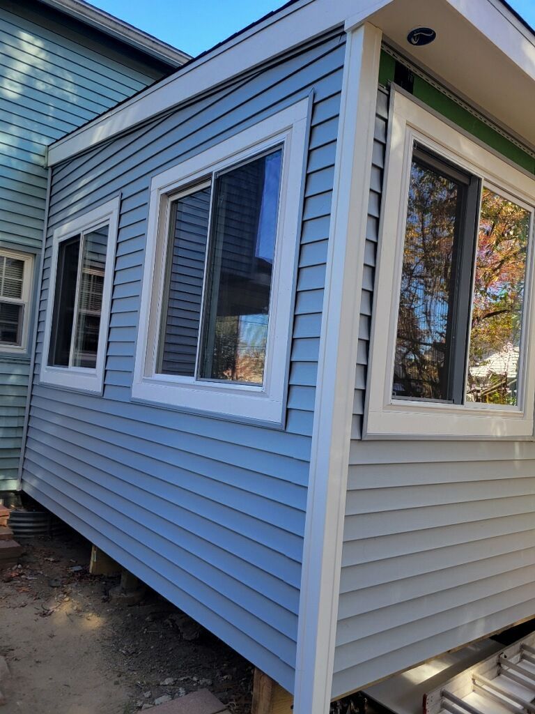 A blue house with white siding and windows is being built.