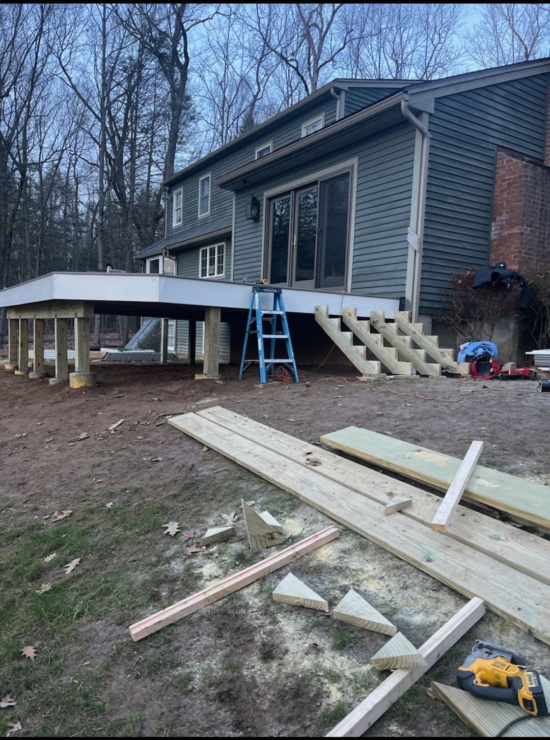 A wooden deck is being built in front of a house.