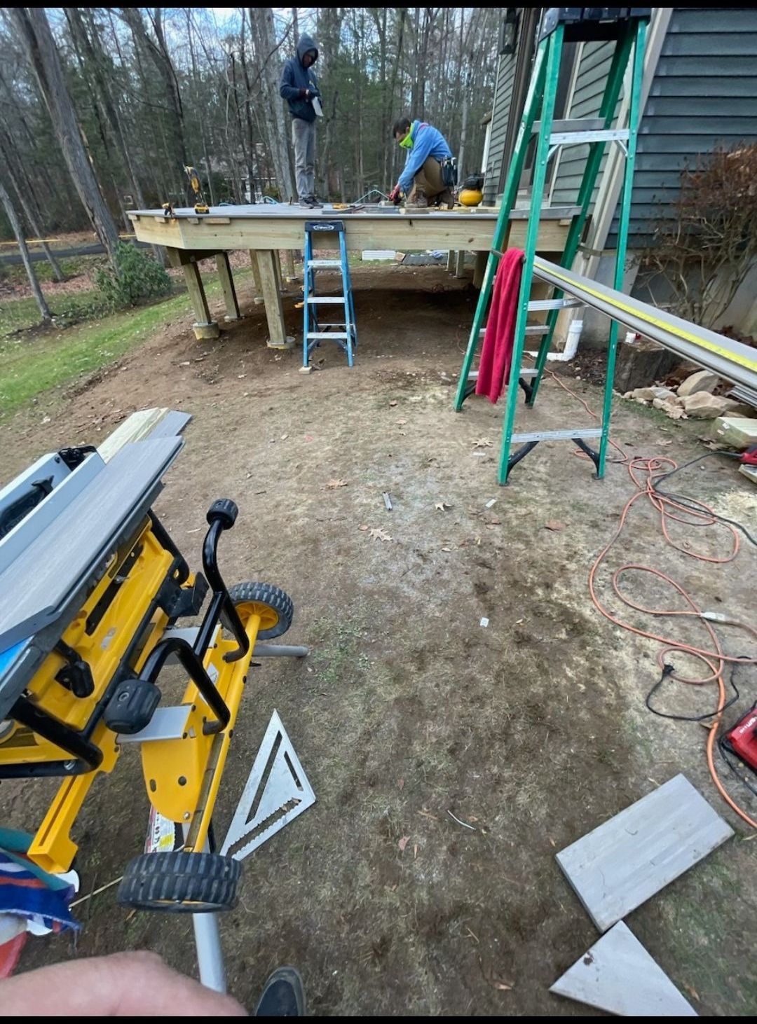 A man is standing on top of a wooden deck.