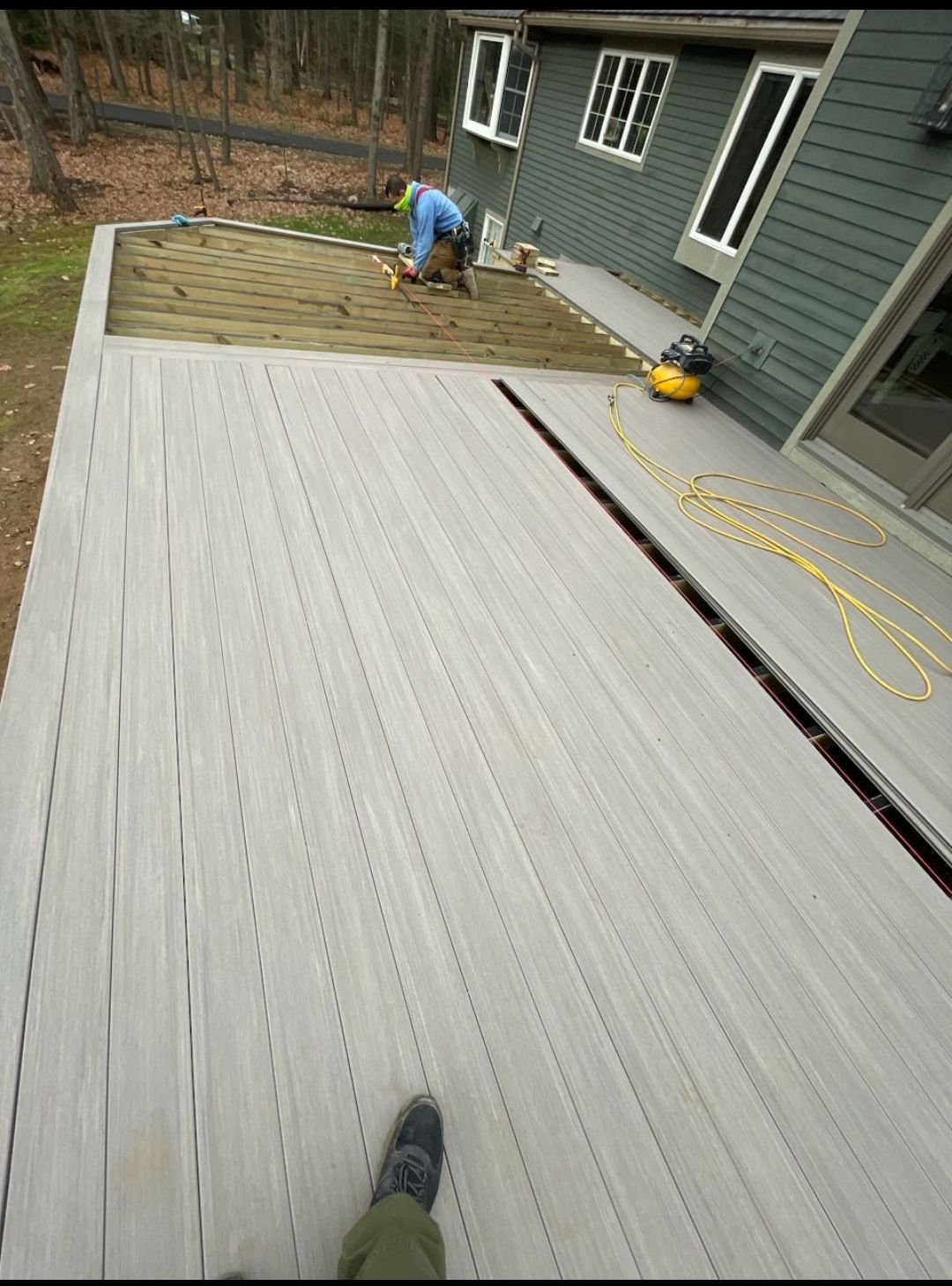 A man is working on a deck in front of a house
