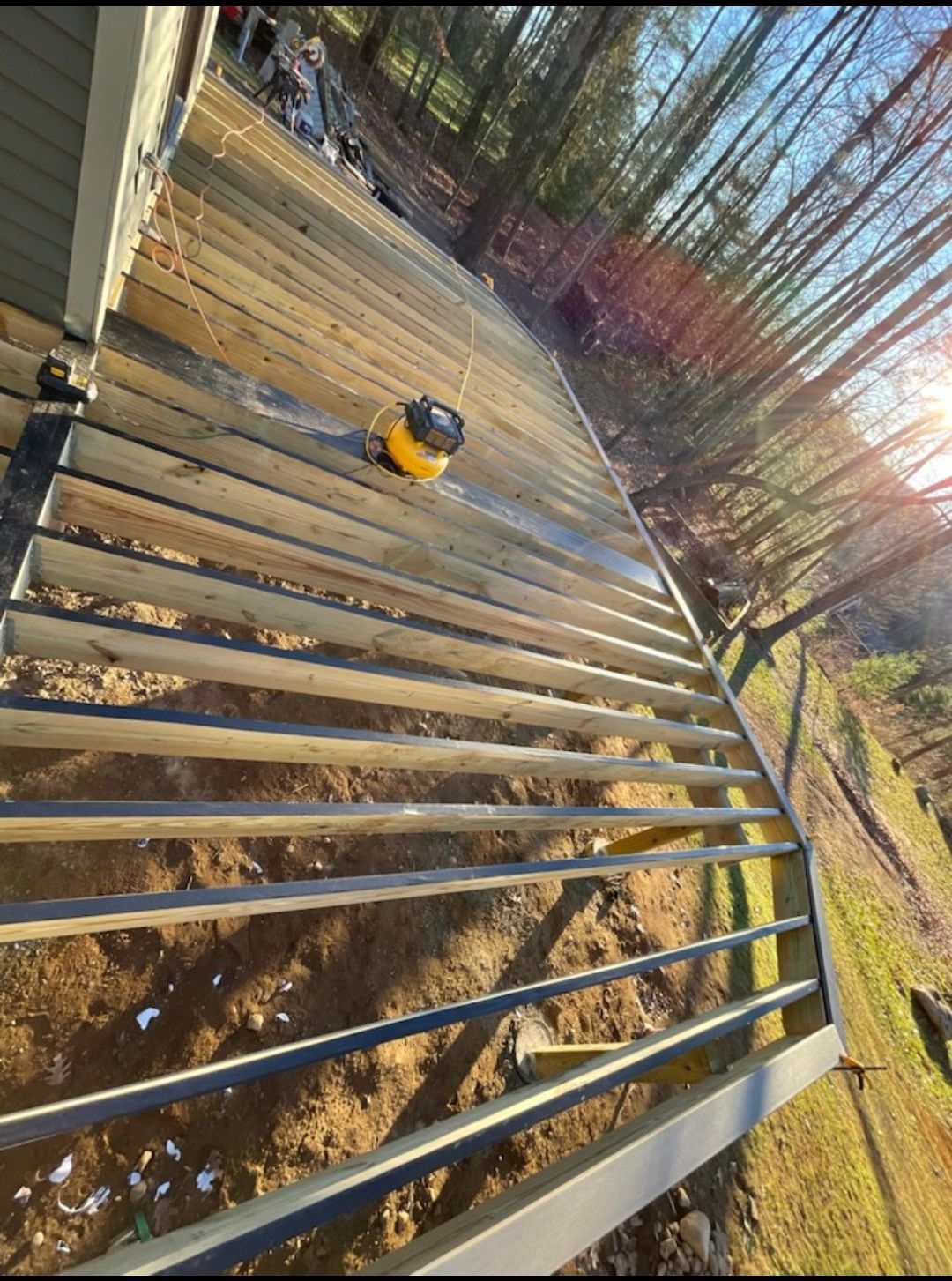 A vacuum cleaner is sitting on top of a wooden deck.