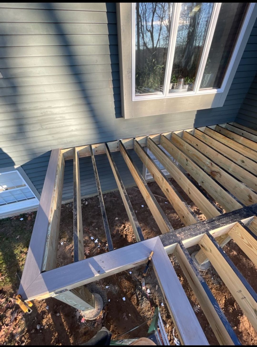 A wooden deck is being built in front of a house.
