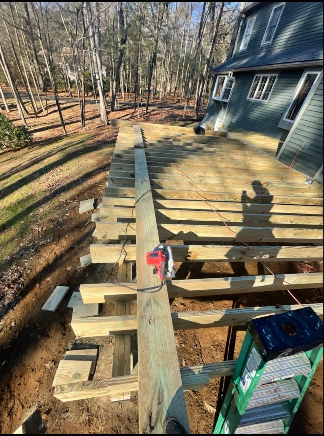 A wooden deck is being built in the backyard of a house.