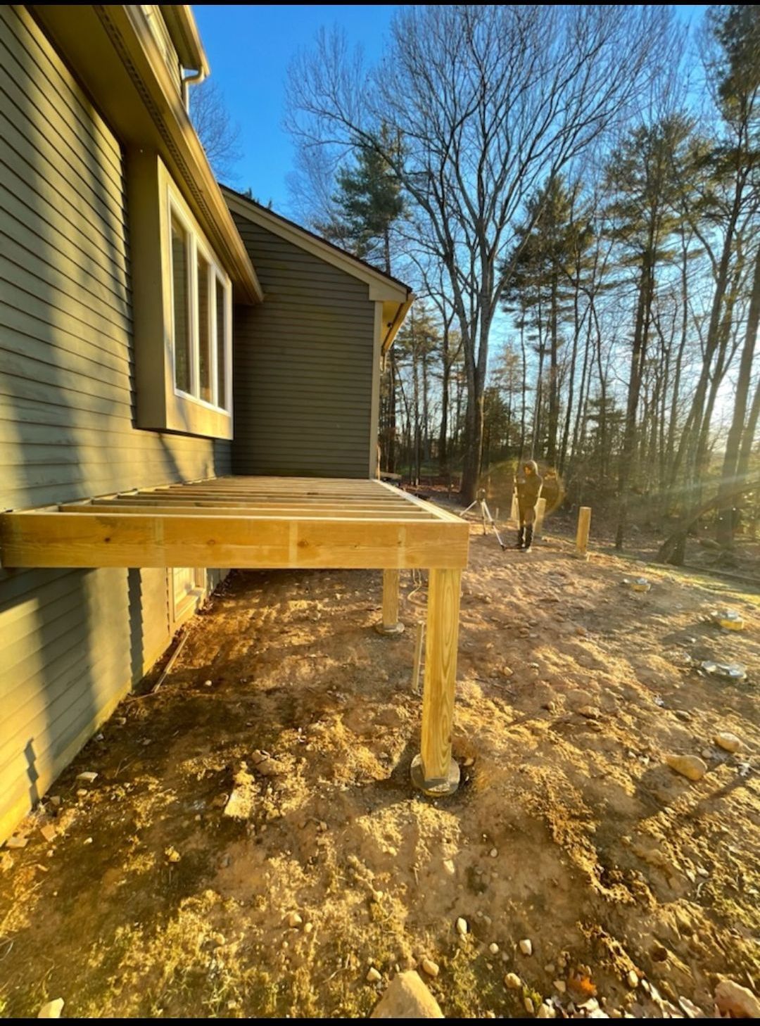 A wooden deck is being built on the side of a house.