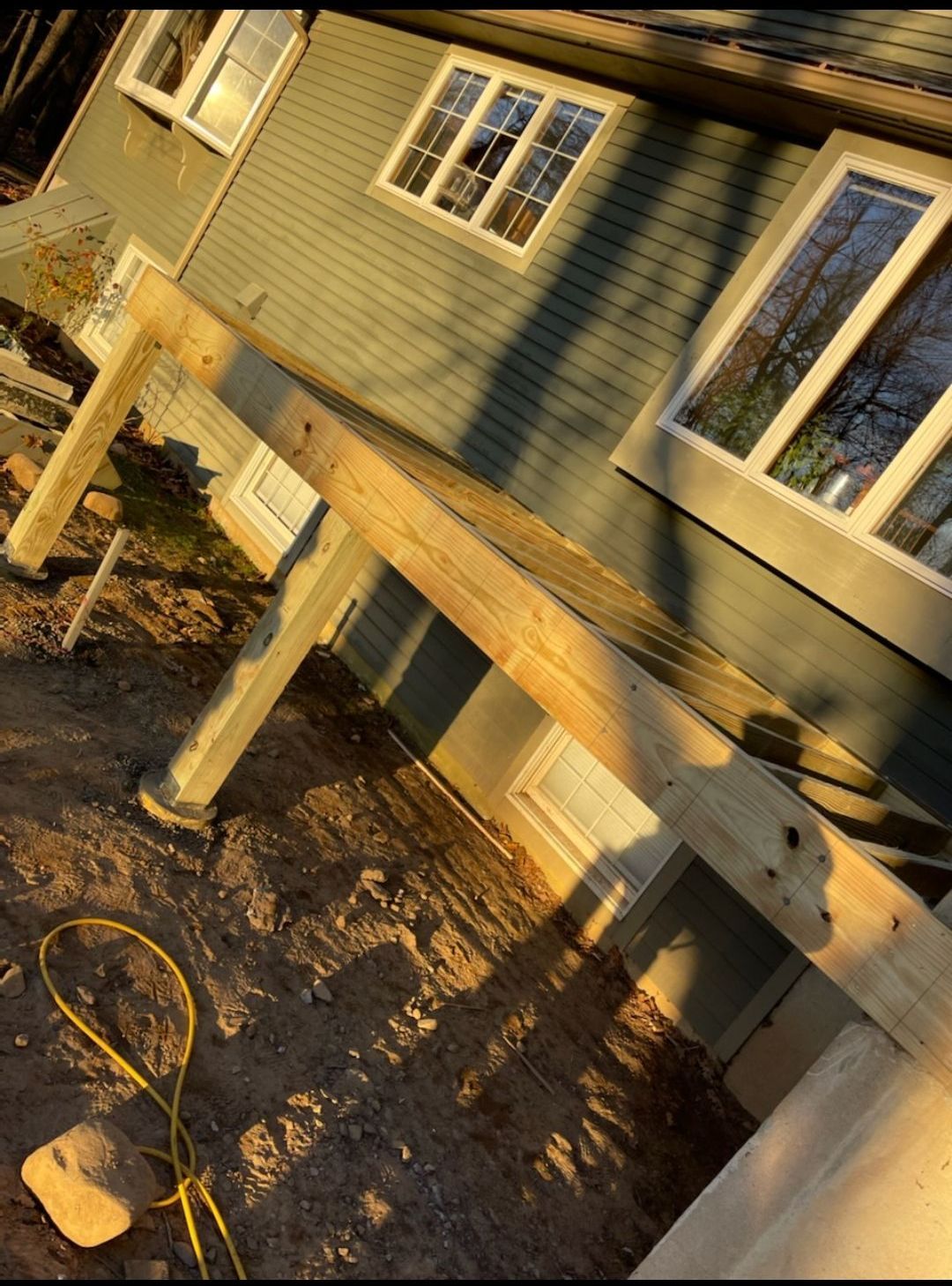 A wooden deck is being built in front of a house.