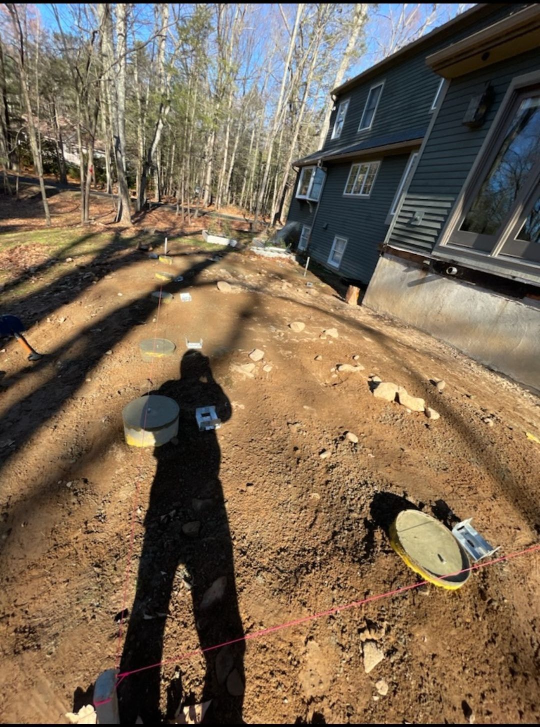 A person is standing in front of a house holding a frisbee.