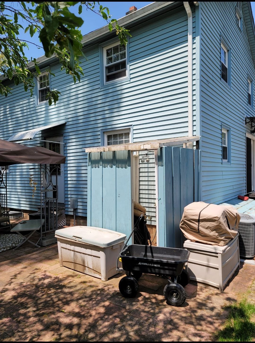 A blue house with a black wagon parked in front of it.