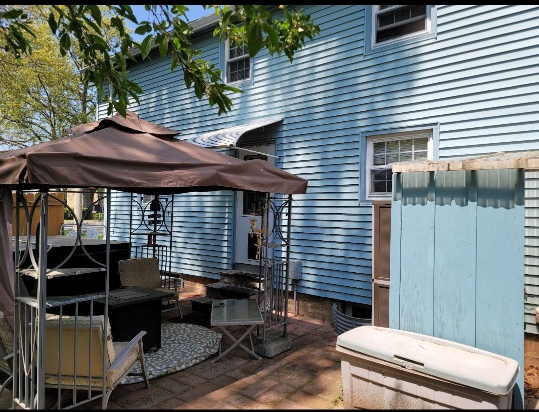 A blue house with a gazebo in front of it.