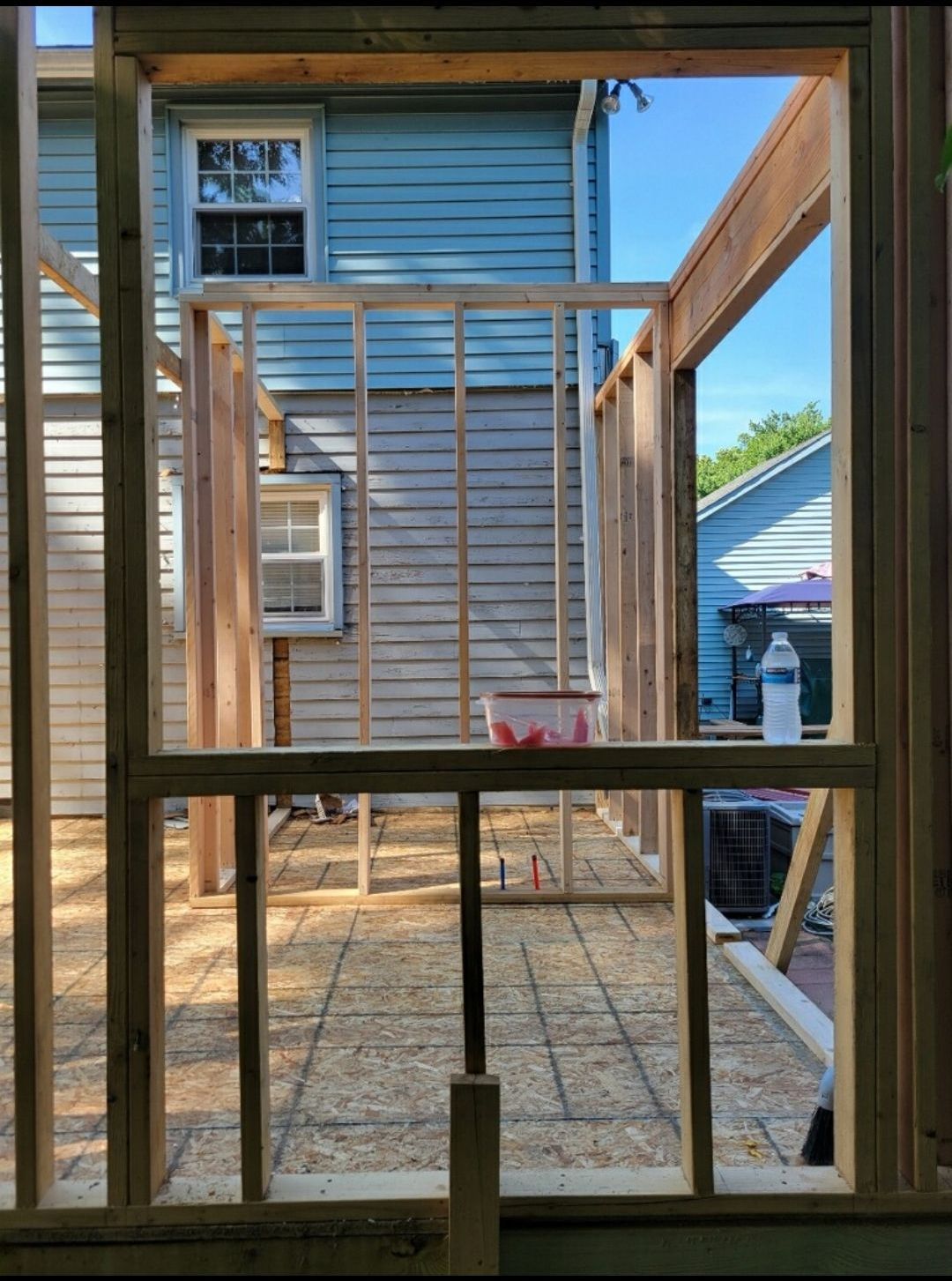 A house is being built and a window is visible through a wooden frame.