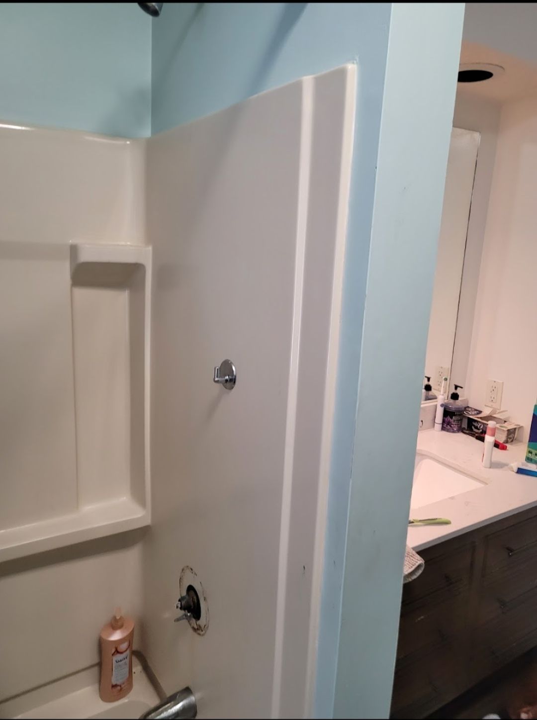 A bathroom with a shower stall and a sink