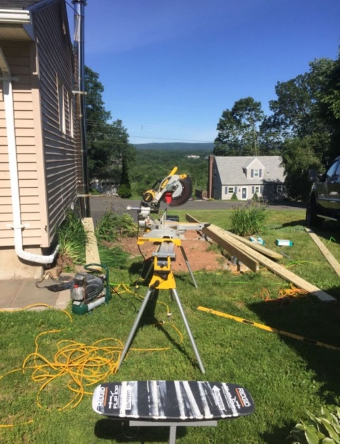 A house is being built on a lush green hillside.