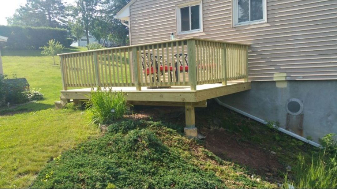 A wooden deck is attached to the side of a house.