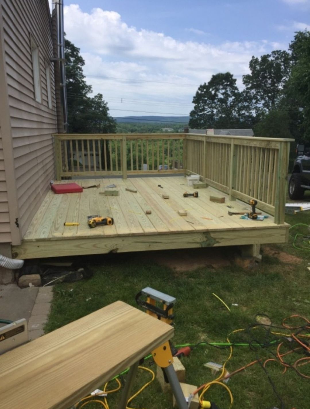 A wooden deck is being built in the backyard of a house.